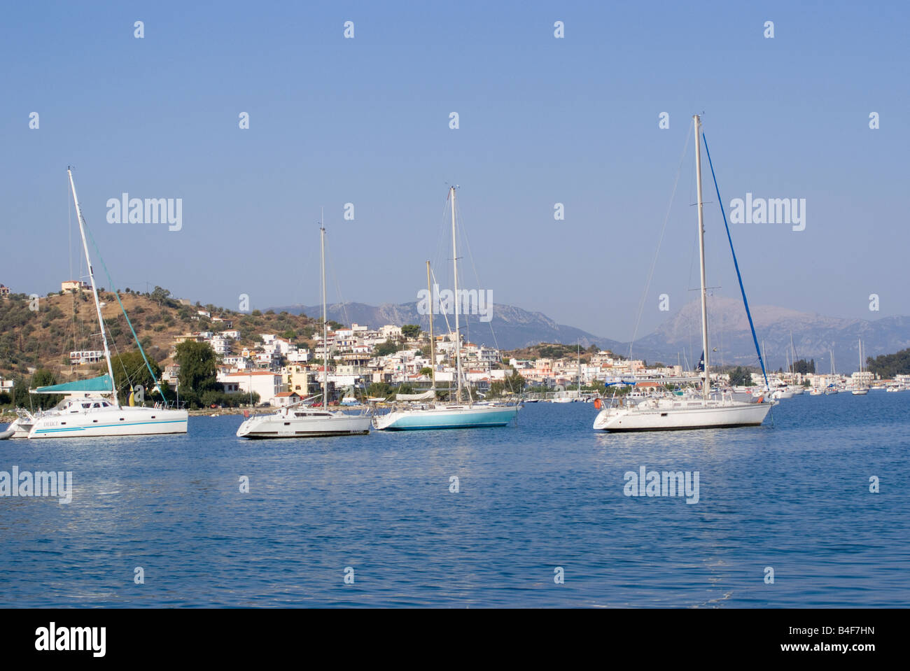 Yachts Moored in the Aegean Sea with Galatas Town in Mainland Greece in Background Stock Photo