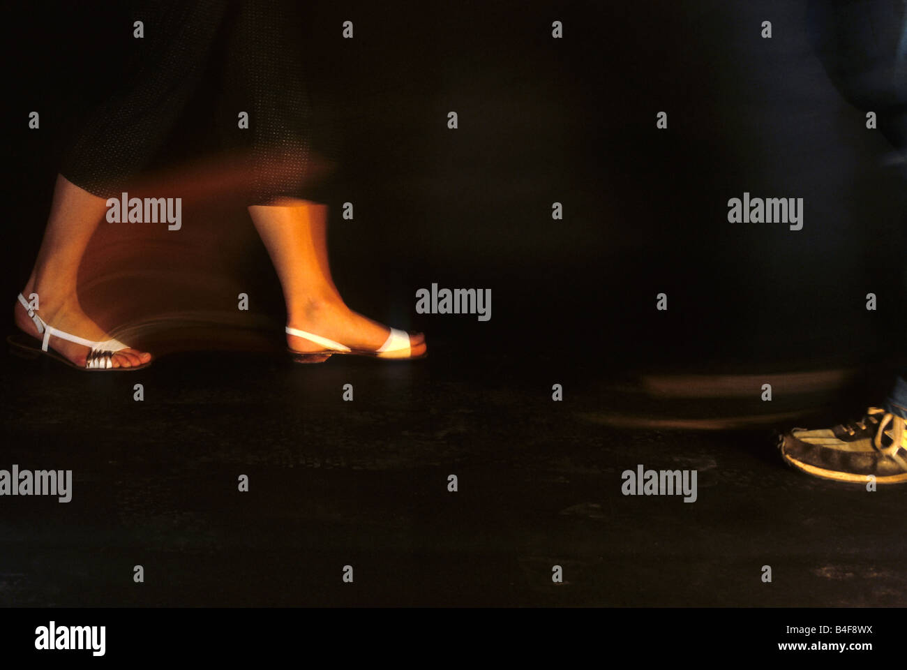 Feet of two people walking in the dark Stock Photo
