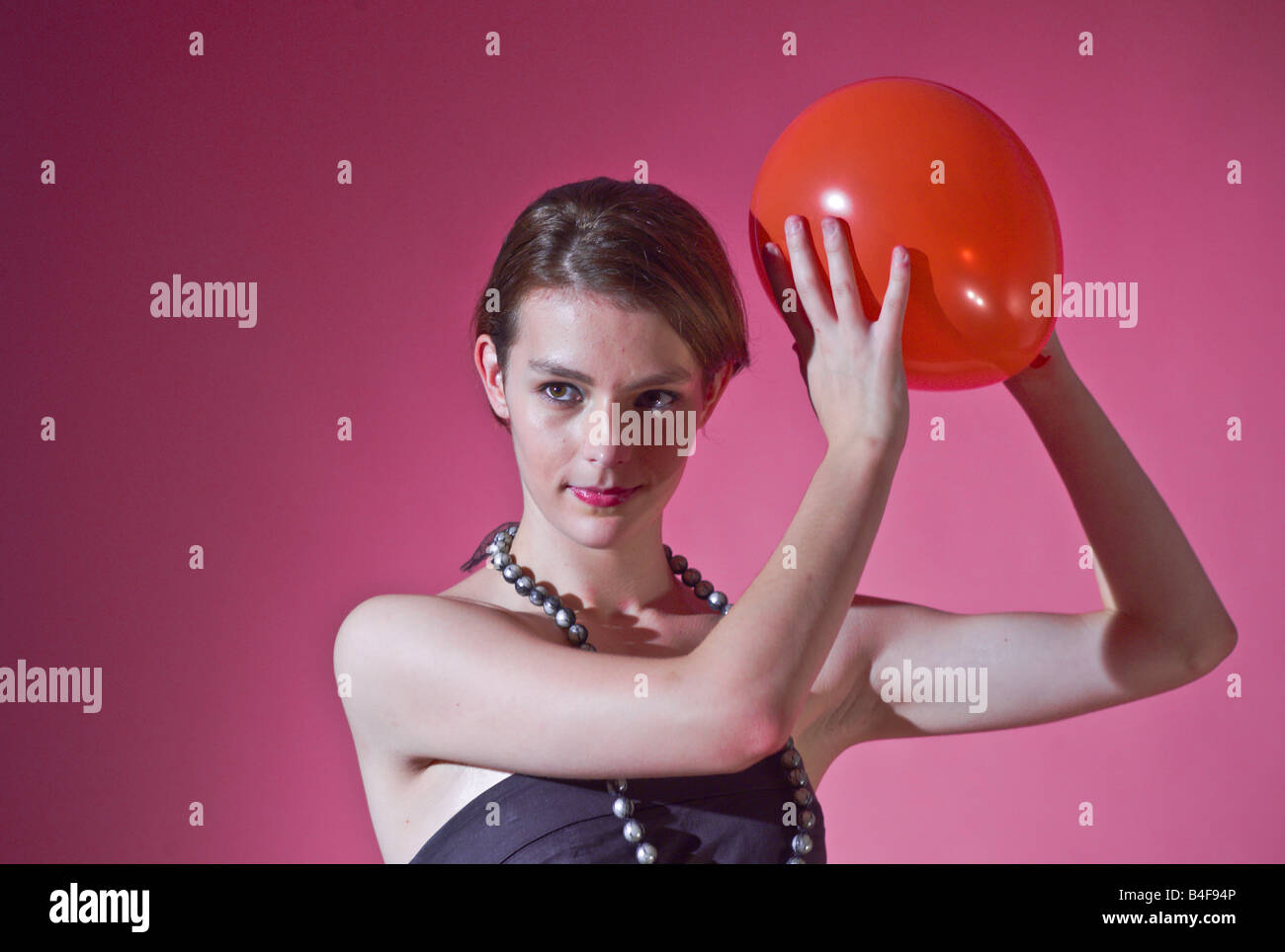 Model in black dress with the red ball model released Stock Photo