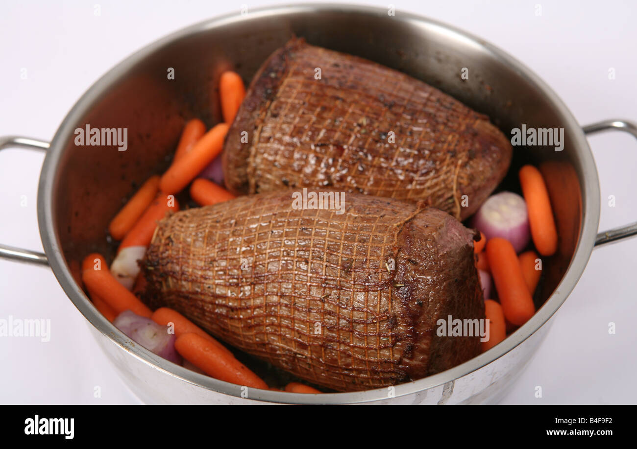 Round beef joints browned ready for braising pot roasting in a Dutch