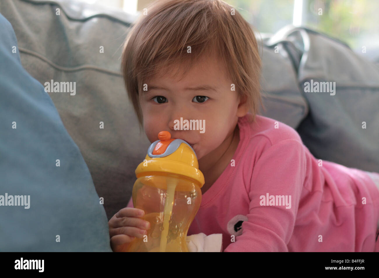 2 year old toddler girl drinking juice from plastic cup with plastic straw  Stock Photo - Alamy