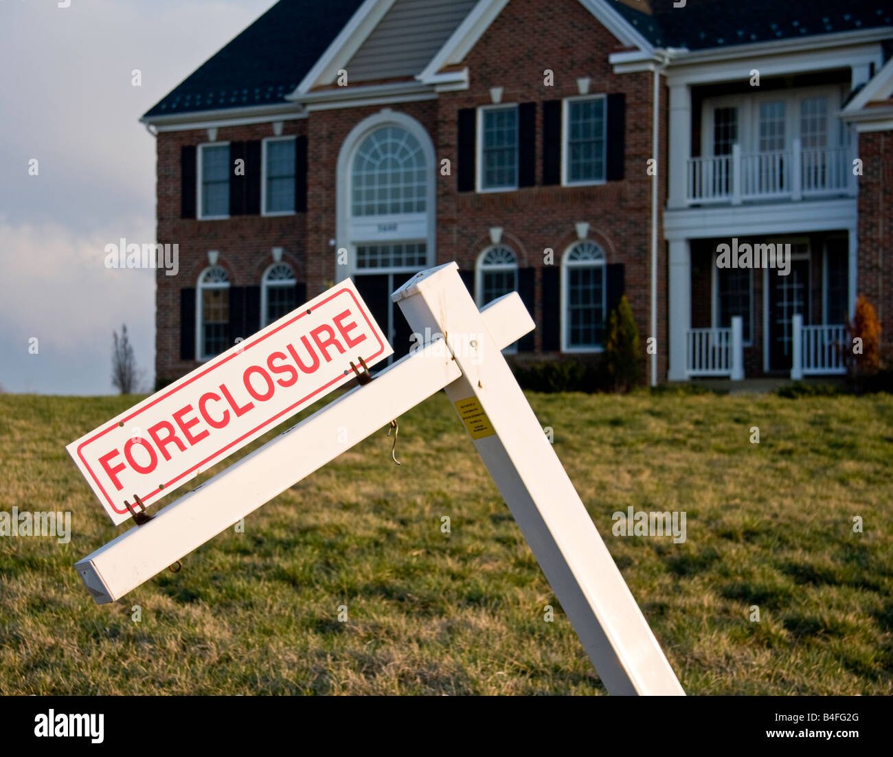 Foreclosure sign in front of a large single family home Stock Photo