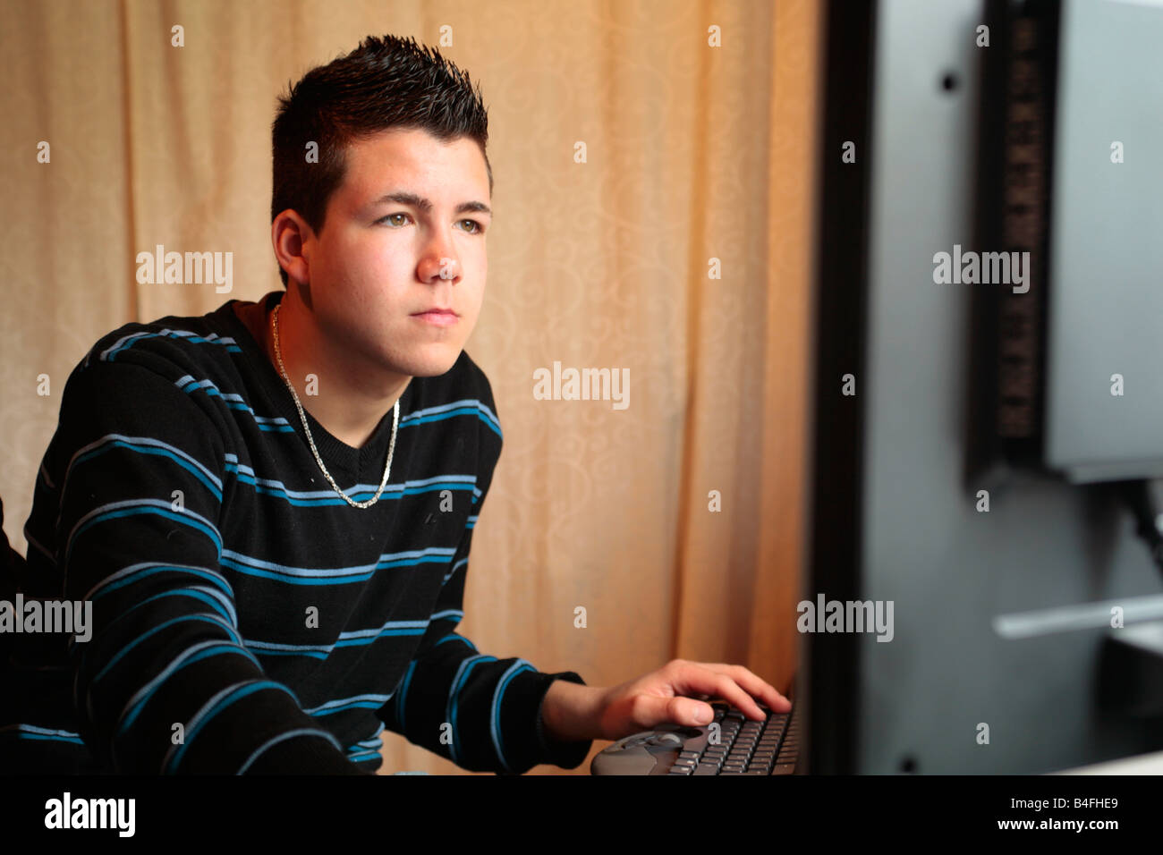 Portait of a teenage boy in front of his computer Stock Photo