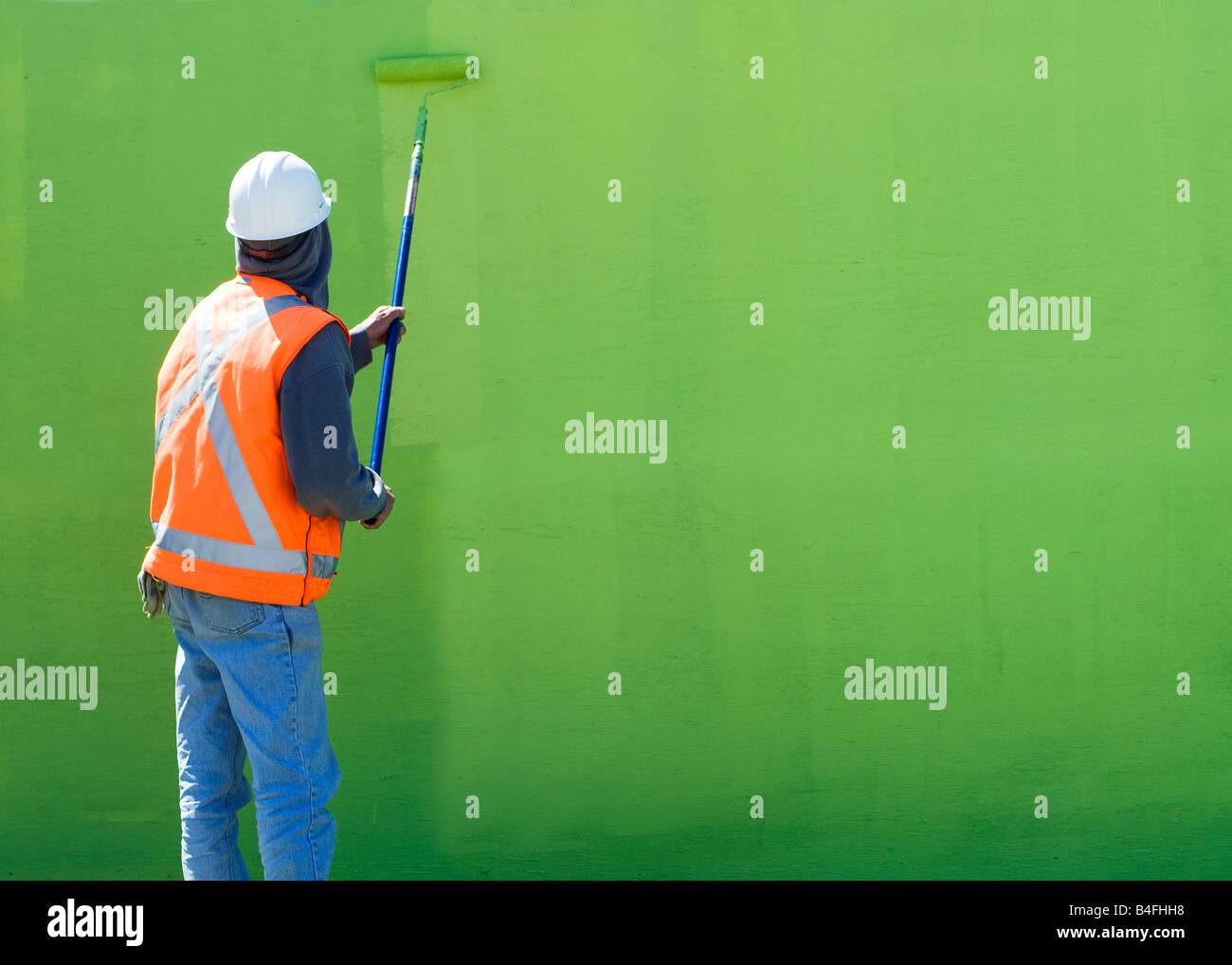 Painter painting wall green color at a construction site in New York City Stock Photo