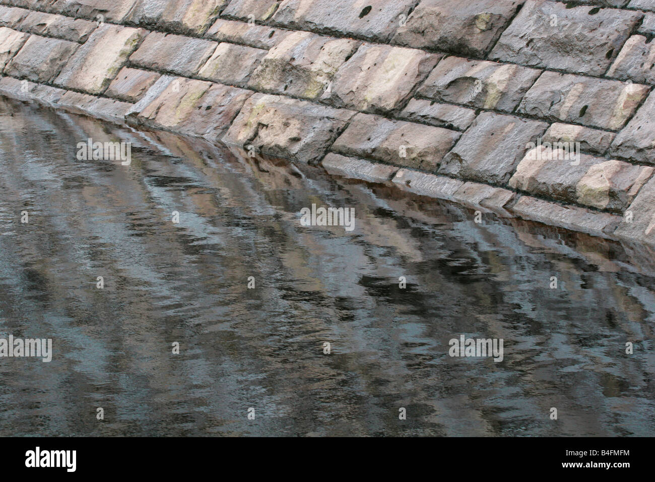 Part of a dam wall reflected in the Ladybower reservoir, Derbyshire Stock Photo