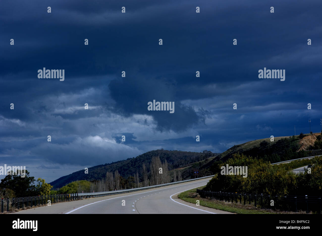 A road in Australia winds beneath a storm Stock Photo Alamy