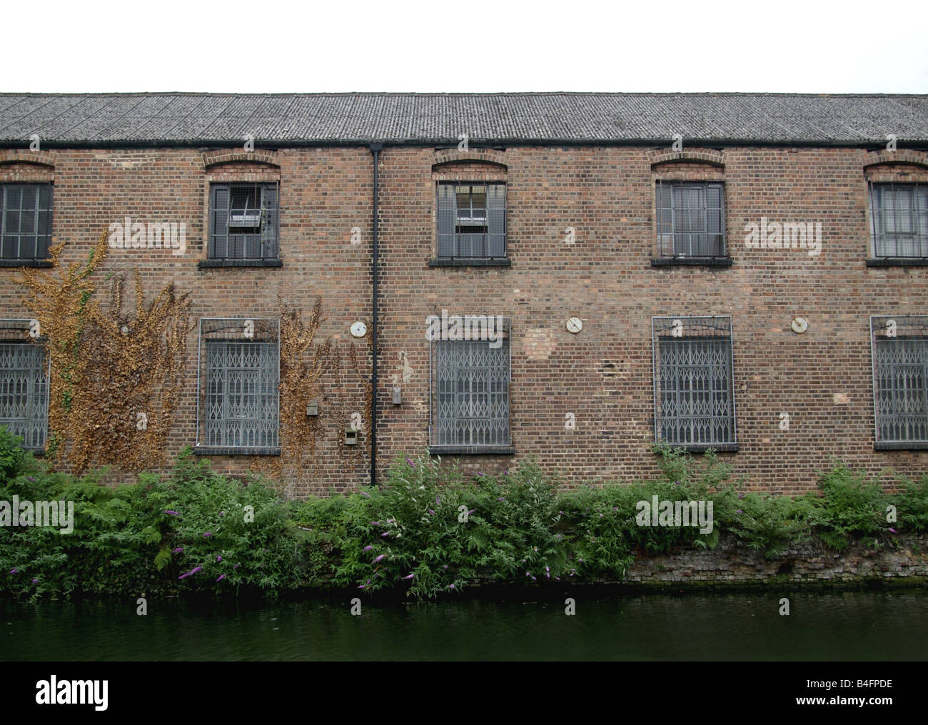 Run down factory buildings alongside the canal in London Stock Photo