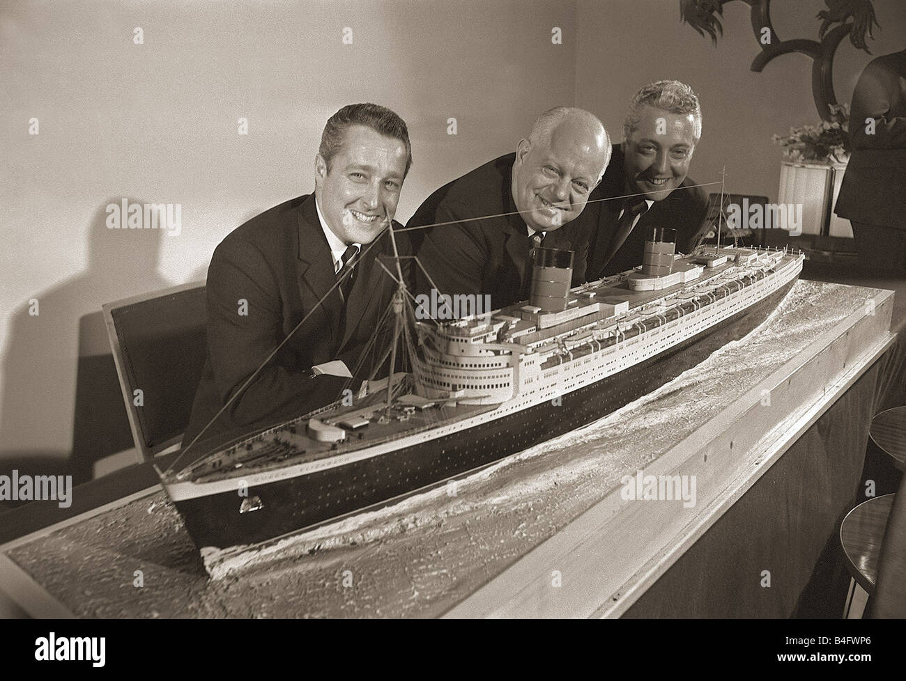 Philadelphia group buy the liner Queen Elizabeth April 1968 Robert B Miller Charles F Williard and Stanton R Miller at the Savoy hotel with a model of the Cunard Line s Queen Elizabeth Liner after buying the Ship for 3 230 000 Philadelphia group buy the Queen Elizabeth Robert B Miller Charles F Williard and Stanton R Miller at the Savoy hotel with a model of the Cunard Line s Queen Elizabeth Liner after buying the Ship for 3 230 000 Stock Photo