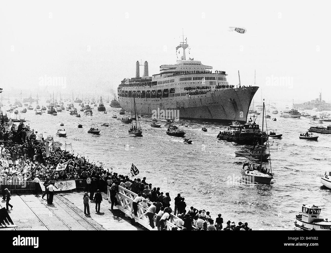 The troop ship SS Canberra is welcomed home from the Falklands War by a flotilla of little boats at Southampton June 1982 Stock Photo