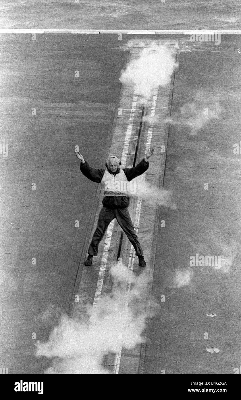 Royal Navy Ships Aircraft Carrier HMS Victorious August 1959 A member of the Launch Flight Deck Crew standing over the steam catapult calls in an aircraft to line up for take off Stock Photo