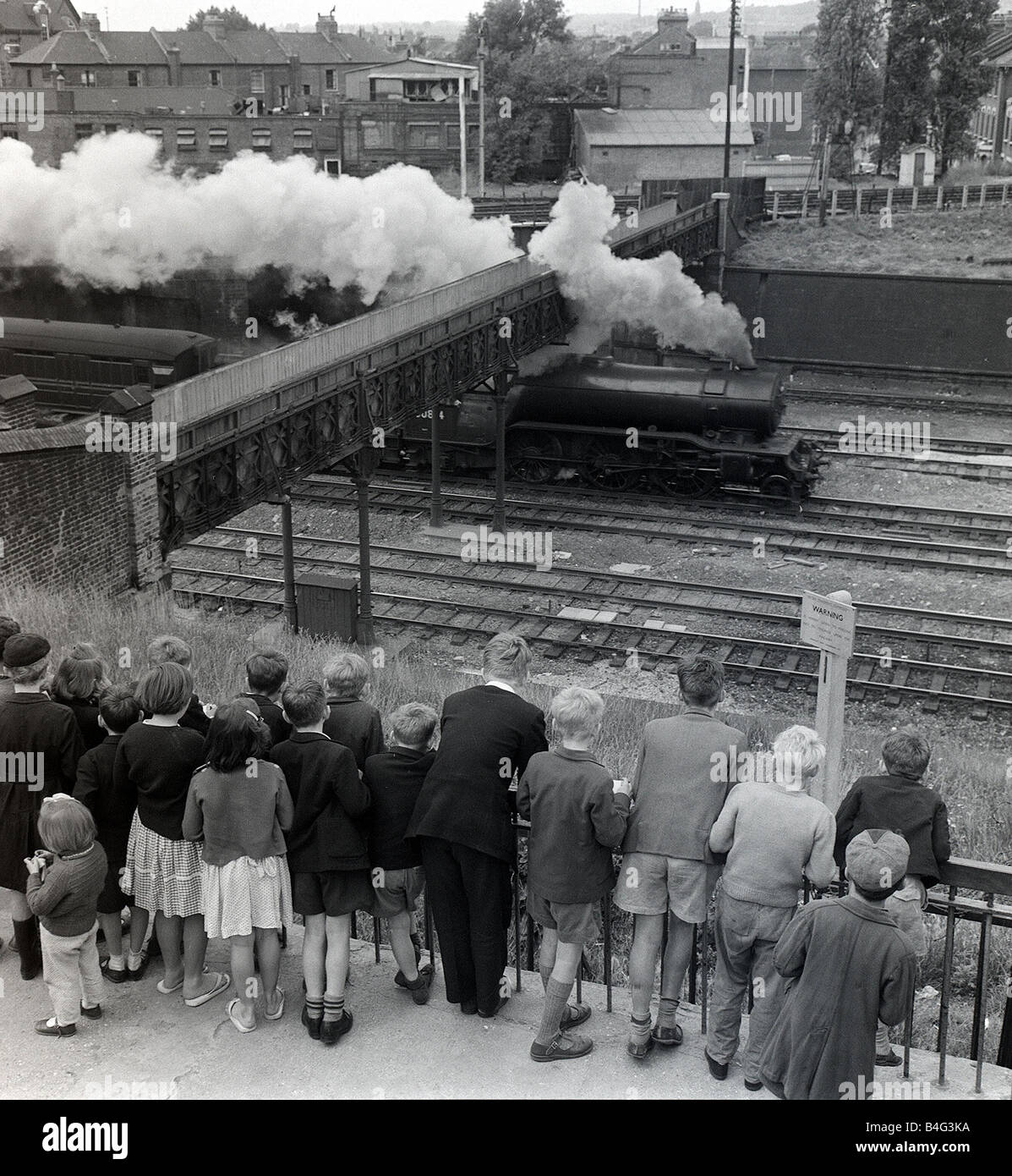 Children Train Spotting July 1960 Children spend many hours watching the trains go by from Finsbury Park They have at their disposal a train spotters platform with times of trains that travel from Kings cross to the North of England and Scotland Stock Photo
