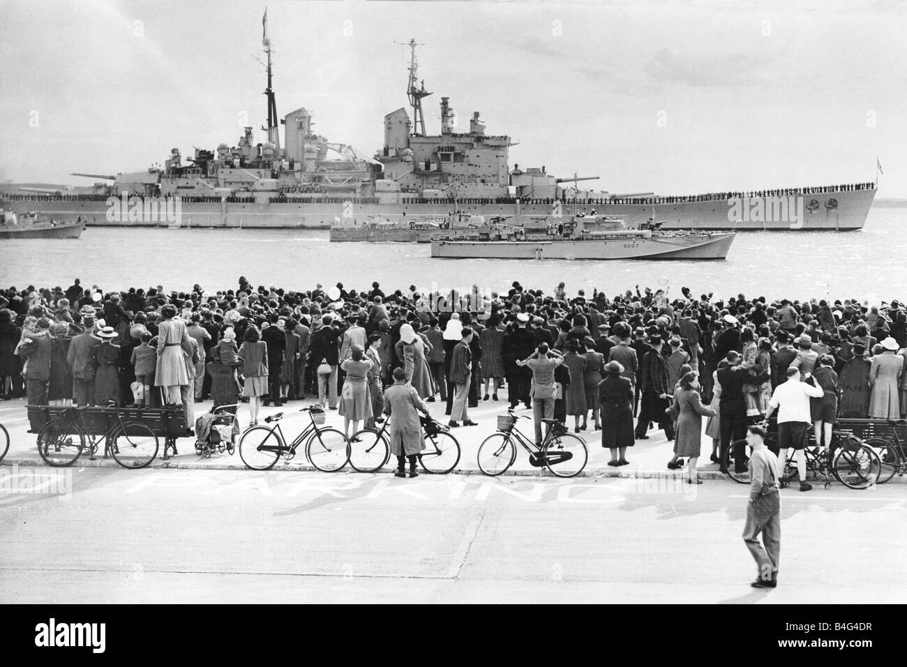HMS Vanguard which took the Royal Family on their tour of South Africa is escorted back into Porstmouth Harbour by Motor Torpedeo Boats As the residents of Portsmouth and Southsea crowd the sea front to greet the battleship and its Royal passengers May 1947 Stock Photo