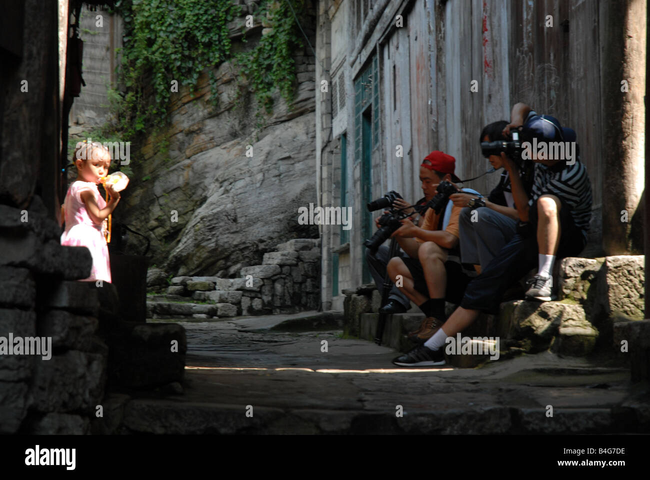 A little village girl gets attention from traveling photographers in rural Chongqhing Municipality, China. Stock Photo