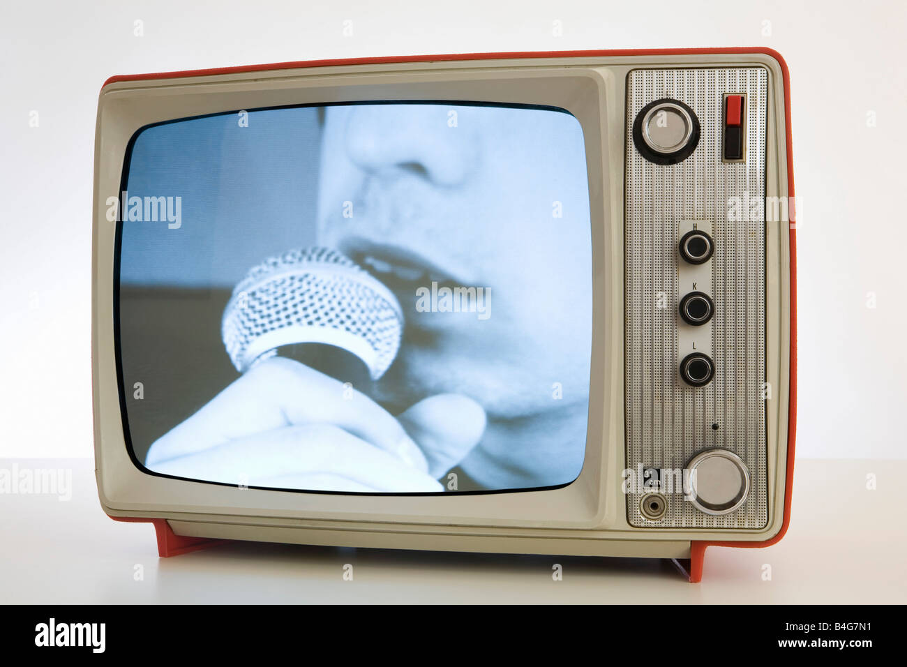 A television with a black and white image of a person singing into a microphone Stock Photo
