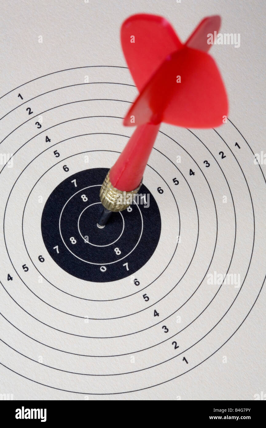 A dart hitting a bull's eye on a paper target Stock Photo