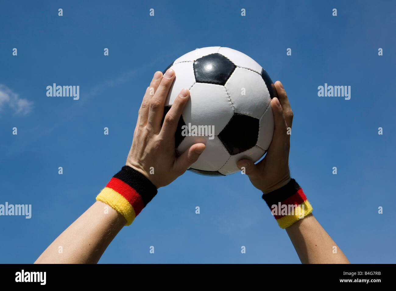 Hands holding a soccer ball in the air Stock Photo Alamy