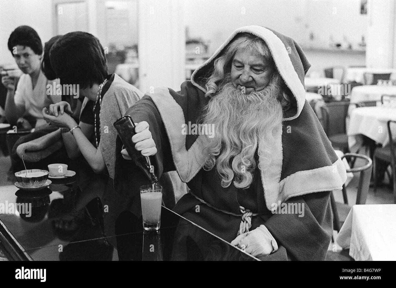 Father Christmas having a drink in a cafe bar in Paris Stock Photo