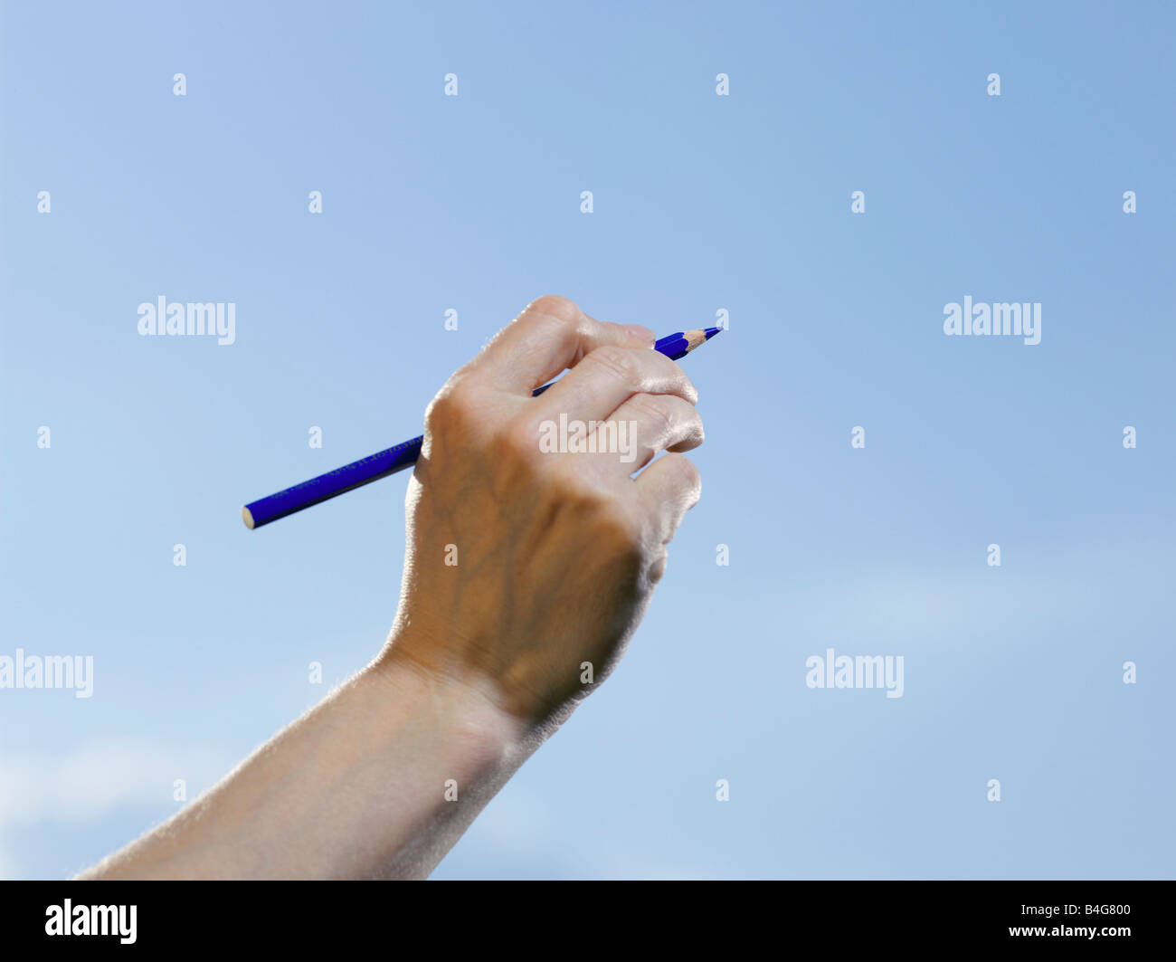 A human hand holding a blue colored pencil Stock Photo - Alamy