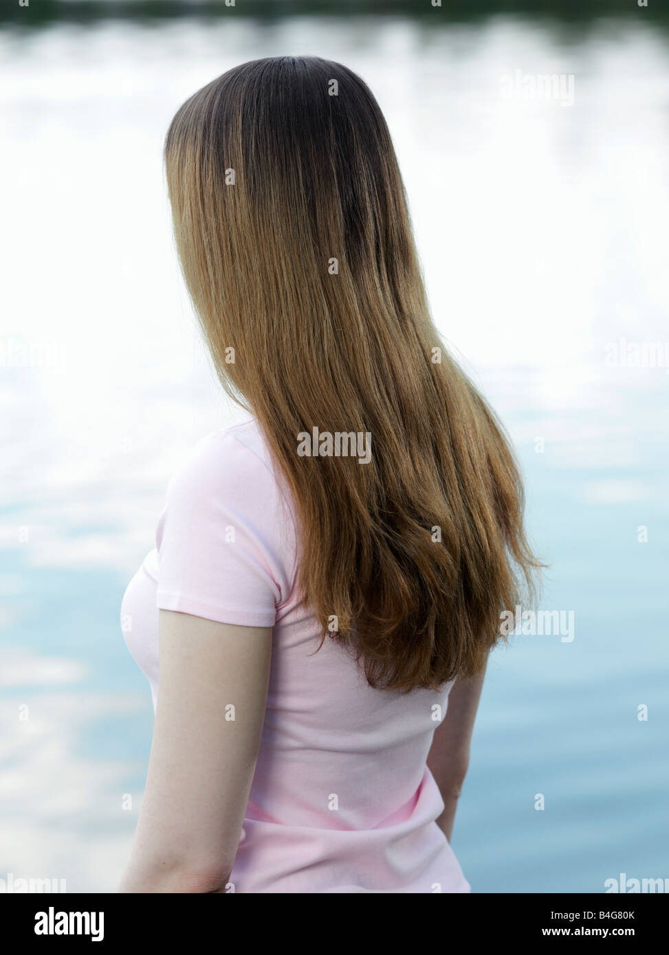 Portrait of a young woman looking out to sea, rear view Stock Photo - Alamy