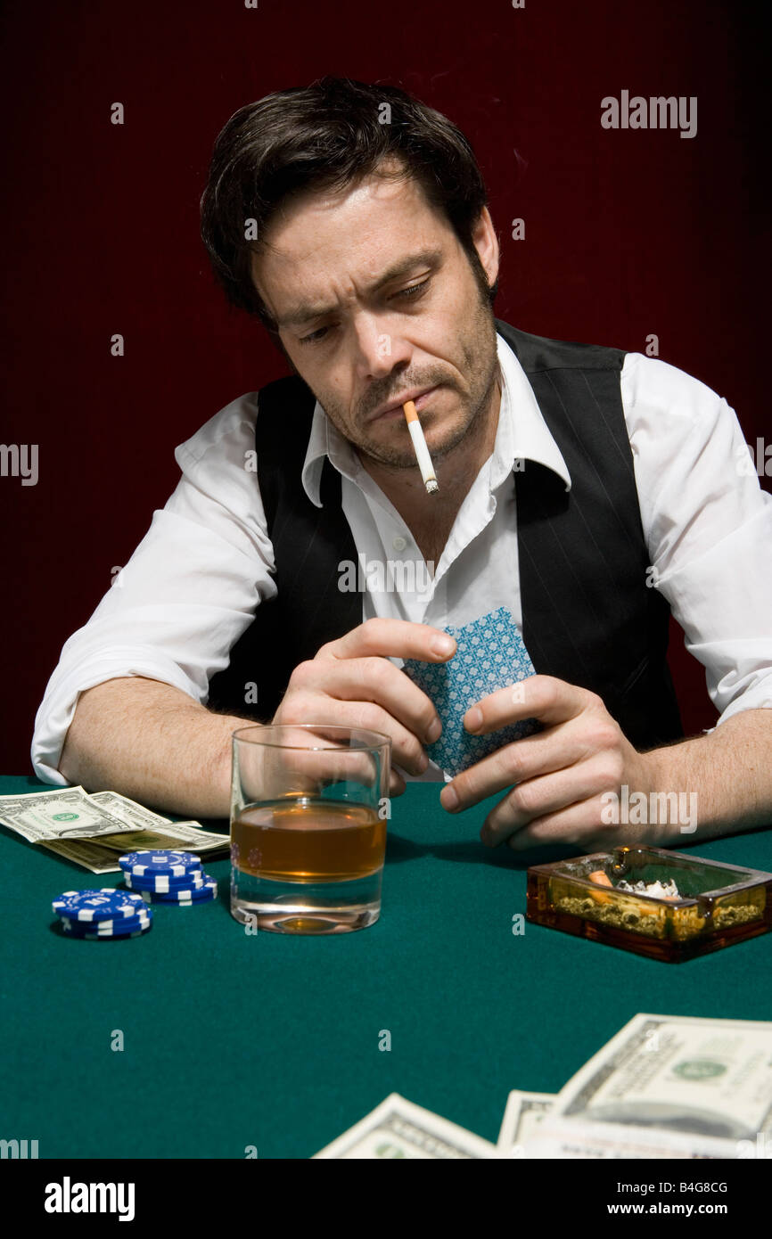 A Man At A High Stakes Poker Game Looking At His Hand Of Cards Stock Photo Alamy