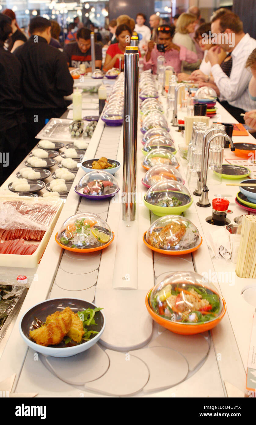 Yo Sushi fish food with prepared dishes moving along past customers Bristol UK Stock Photo - Alamy