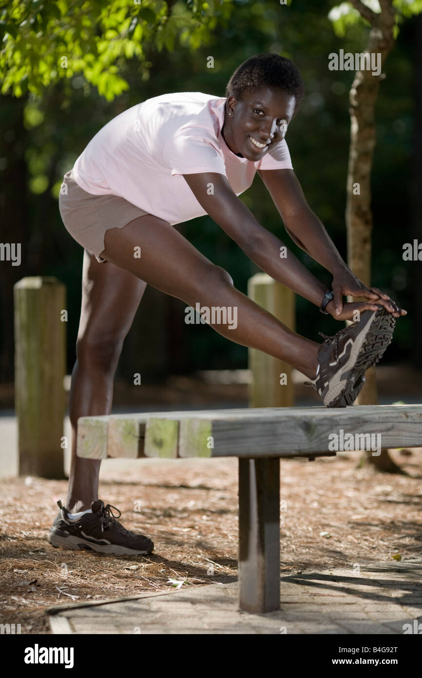 A young woman doing a leg stretch Stock Photo