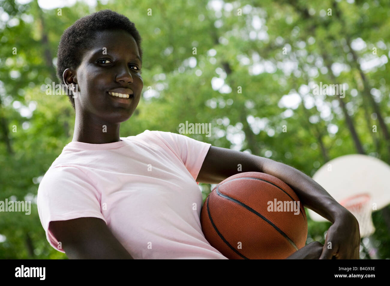 A young woman holding a basketball, outdoors Stock Photo