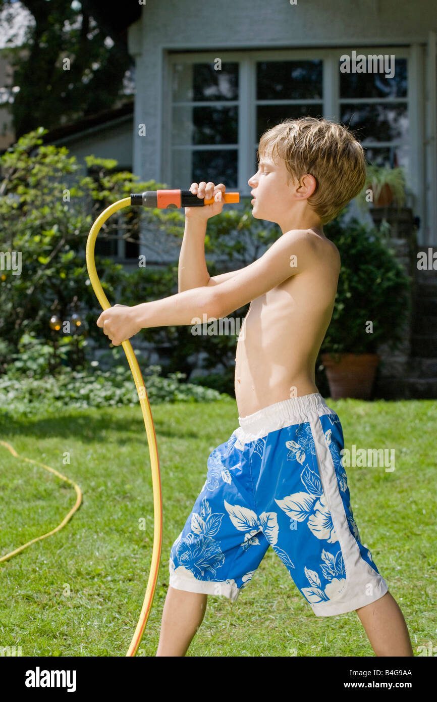 A young boy singing into the end of garden hose Stock Photo - Alamy
