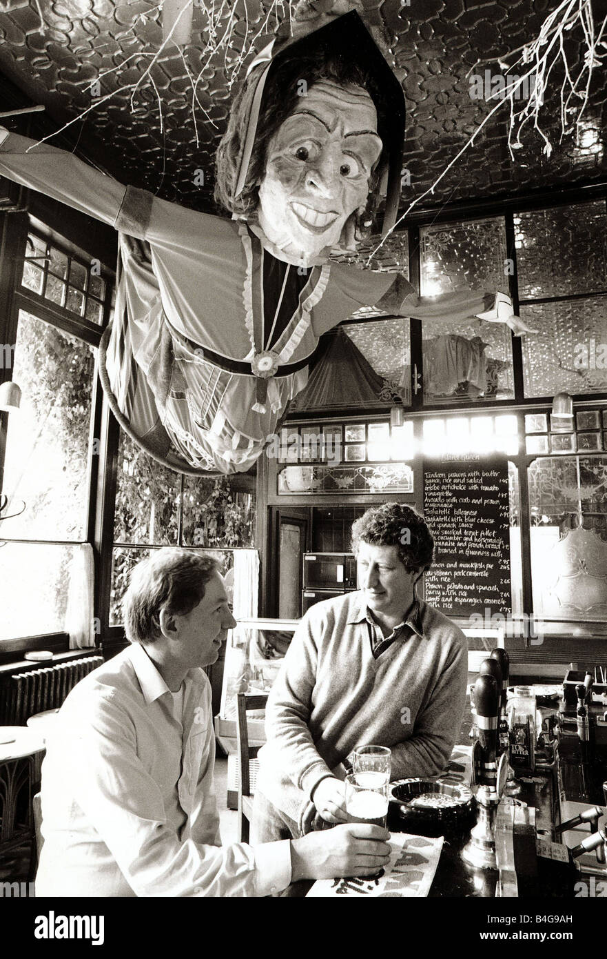 Island Queen Public House Pub June 1987 men standing at the bar enjoying a pint of beer at their local Public Houses Pubs Drinking drinks An ernormus puppet like Judy from punch and judy hanging from the ceiling Stock Photo