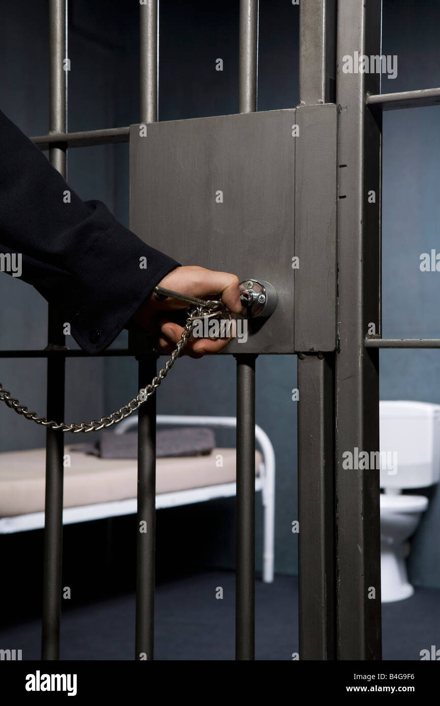 A prison guard unlocking a prison cell door Stock Photo