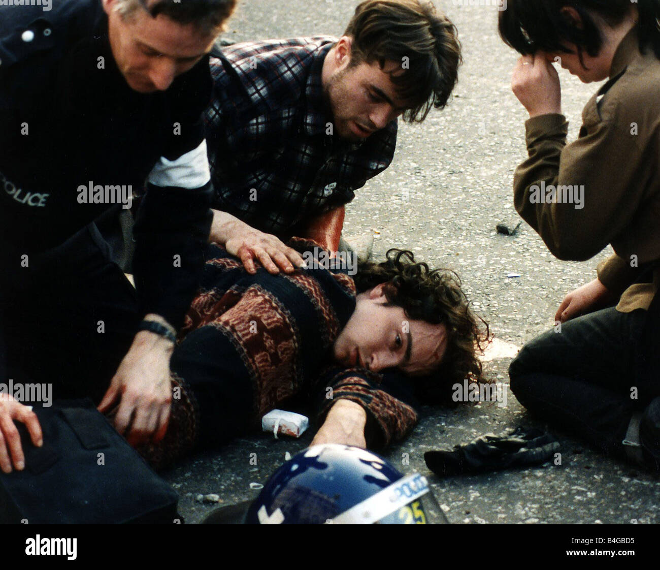 Demonstration Poll Tax March 1990 A man lies bleeding on the ground being attended by a police officer after the riots at Trafalgar Square in London Stock Photo