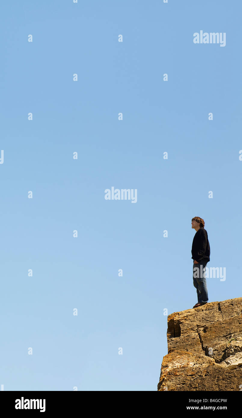 Man Standing On The Edge Of A Cliff With His Arms Outstretched Stock ...