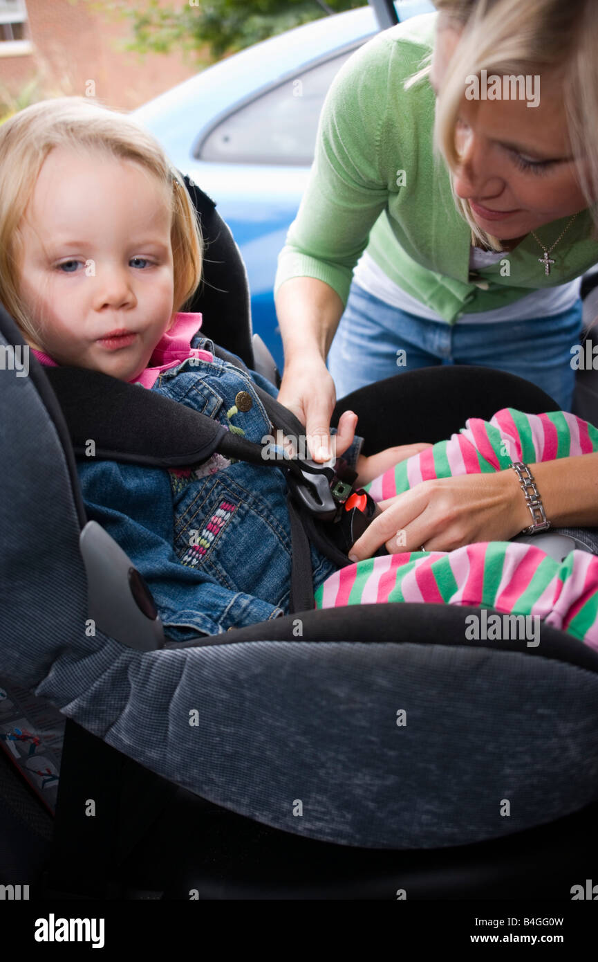 little girl being strapped into her car seat by her mother Stock ... little girl being strapped into her car seat by her mother Stock ...