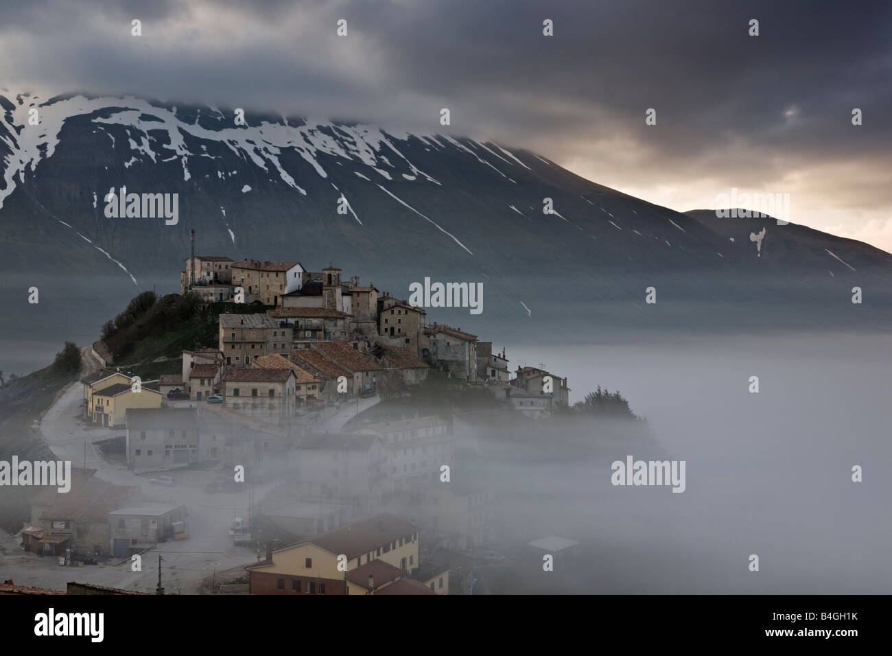 Castellucio village in mist Piano Grande Monti Sibillini National Park Umbria Italy Stock Photo