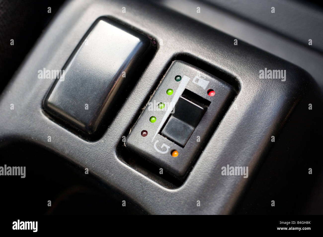 Inside of a vehicle showing aftermarket switch on fascia to put car on LPG fuel power with led LPG fuel gauge UK Stock Photo