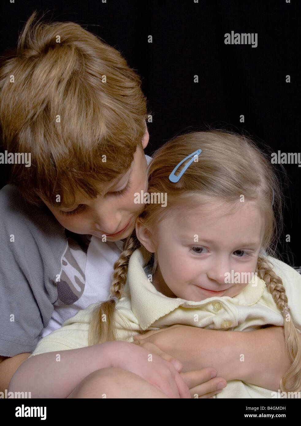 color portrait of two children, male and female, hugging, holding, looking. displaying love and affection towards each other Stock Photo