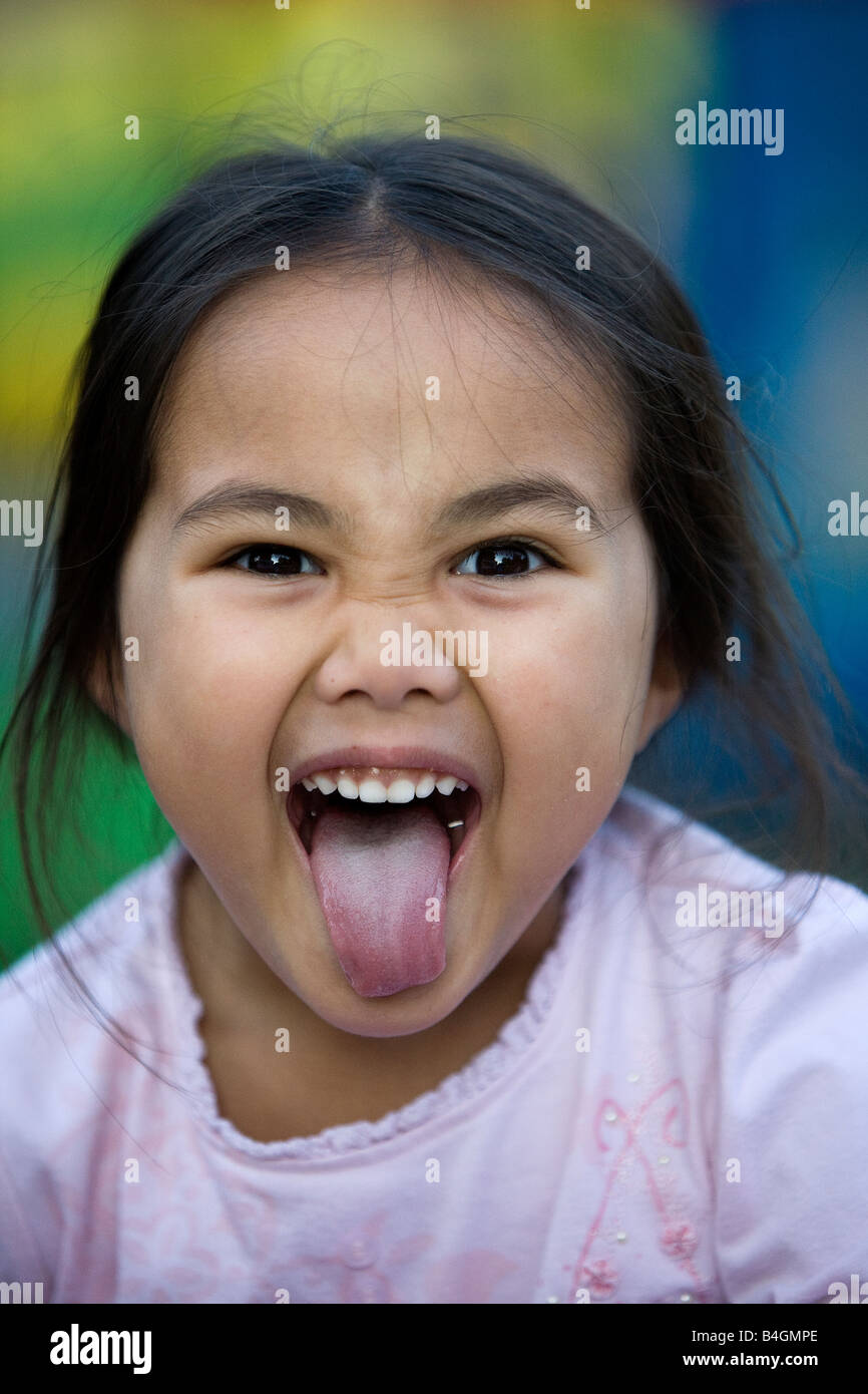 Young girl, whilst playing in a park, saw that she was having her photograph taken and pulled a face at the camera Stock Photo