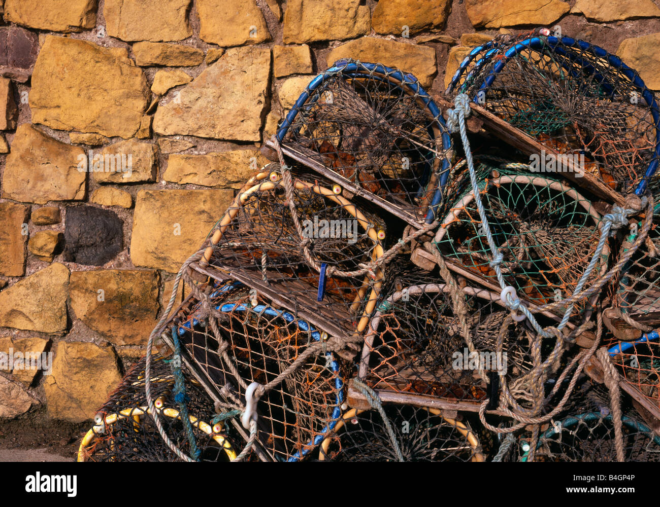 Beadnell, Northumberland, UK. Lobster pots stacked by the harbour in front of the lime kilns. Stock Photo