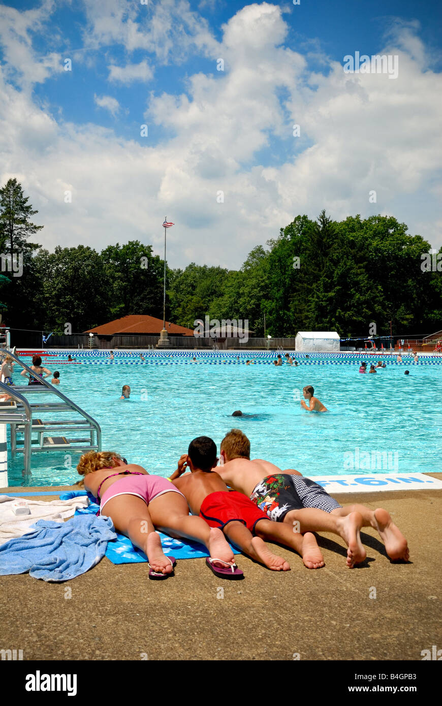 A girl and two boys relax poolside at North Park Pool Pittsburgh PA Stock Photo