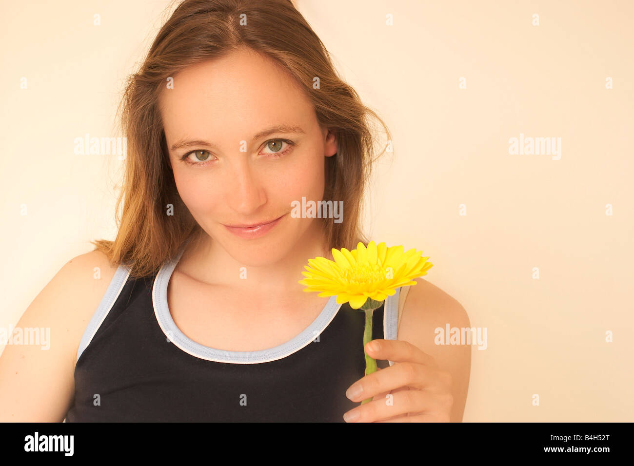 Portrait of young woman holding flower and smiling Stock Photo - Alamy