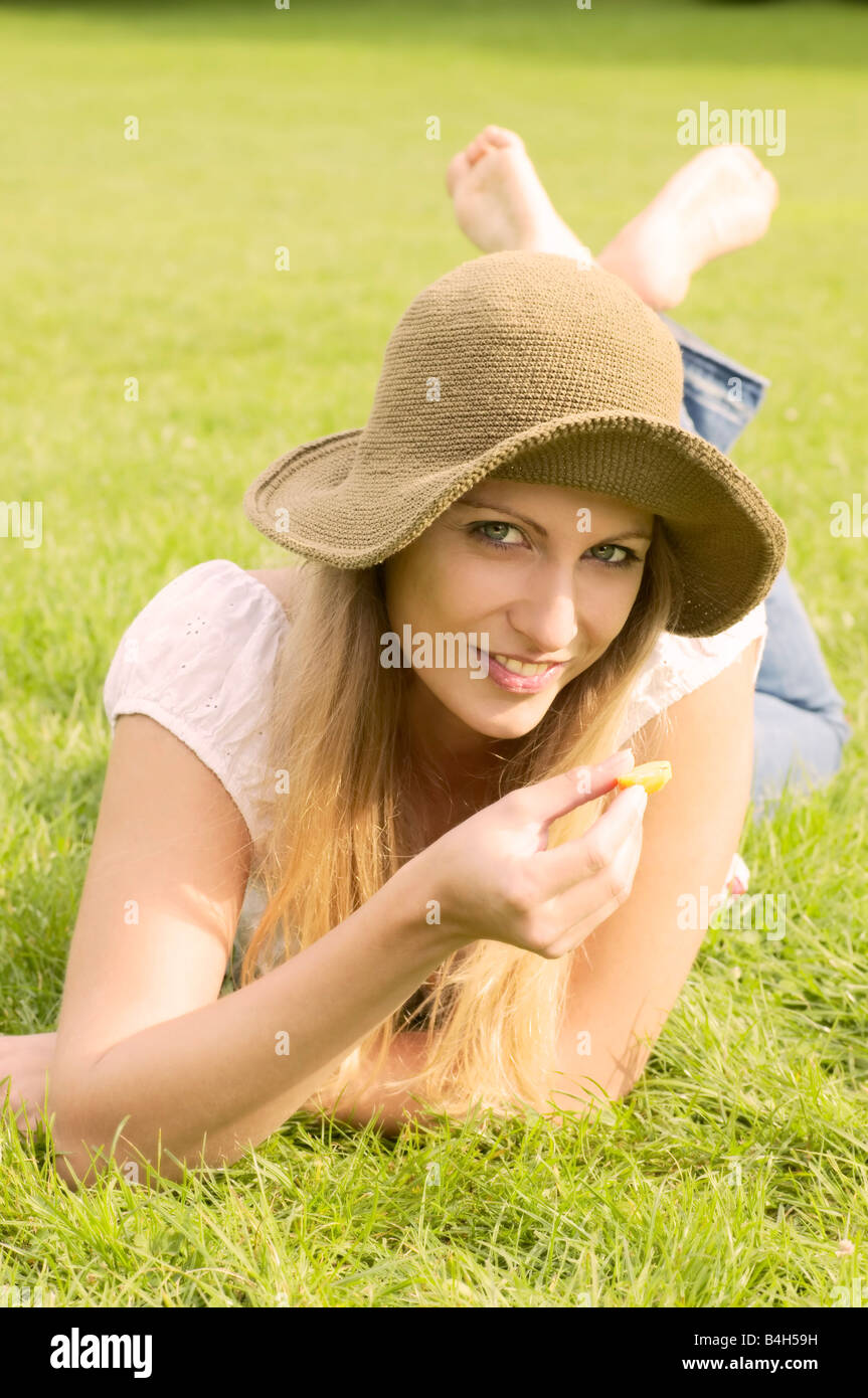 Portrait of woman lying on grass and smiling Stock Photo - Alamy