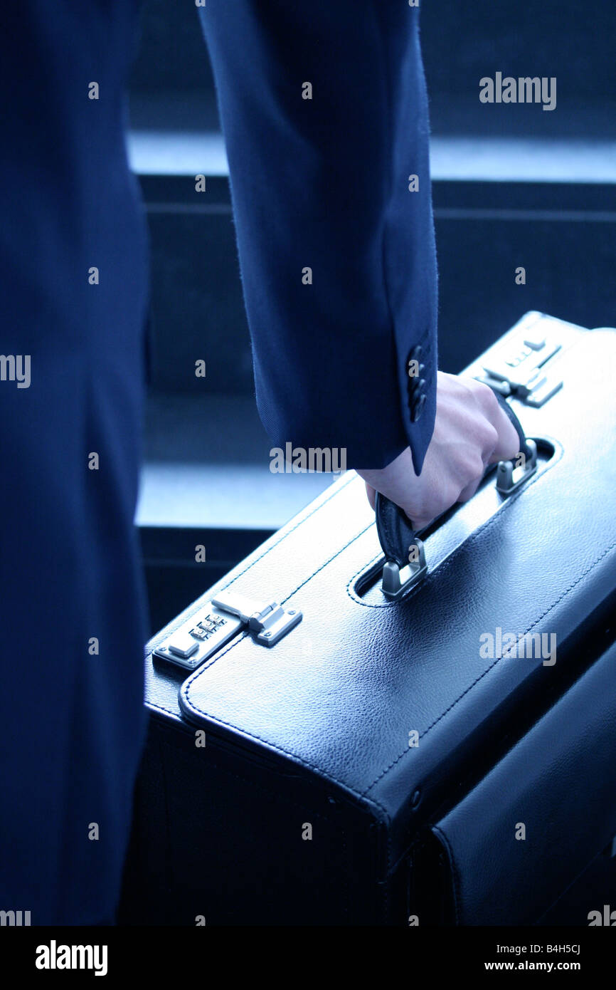 Midsection view of businessman carrying suitcase Stock Photo