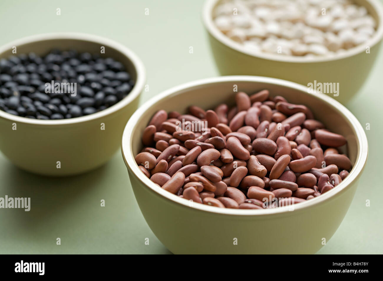 Assorted organic red beans, red kidney beans, and pinto beans in wooden bowls Stock Photo
