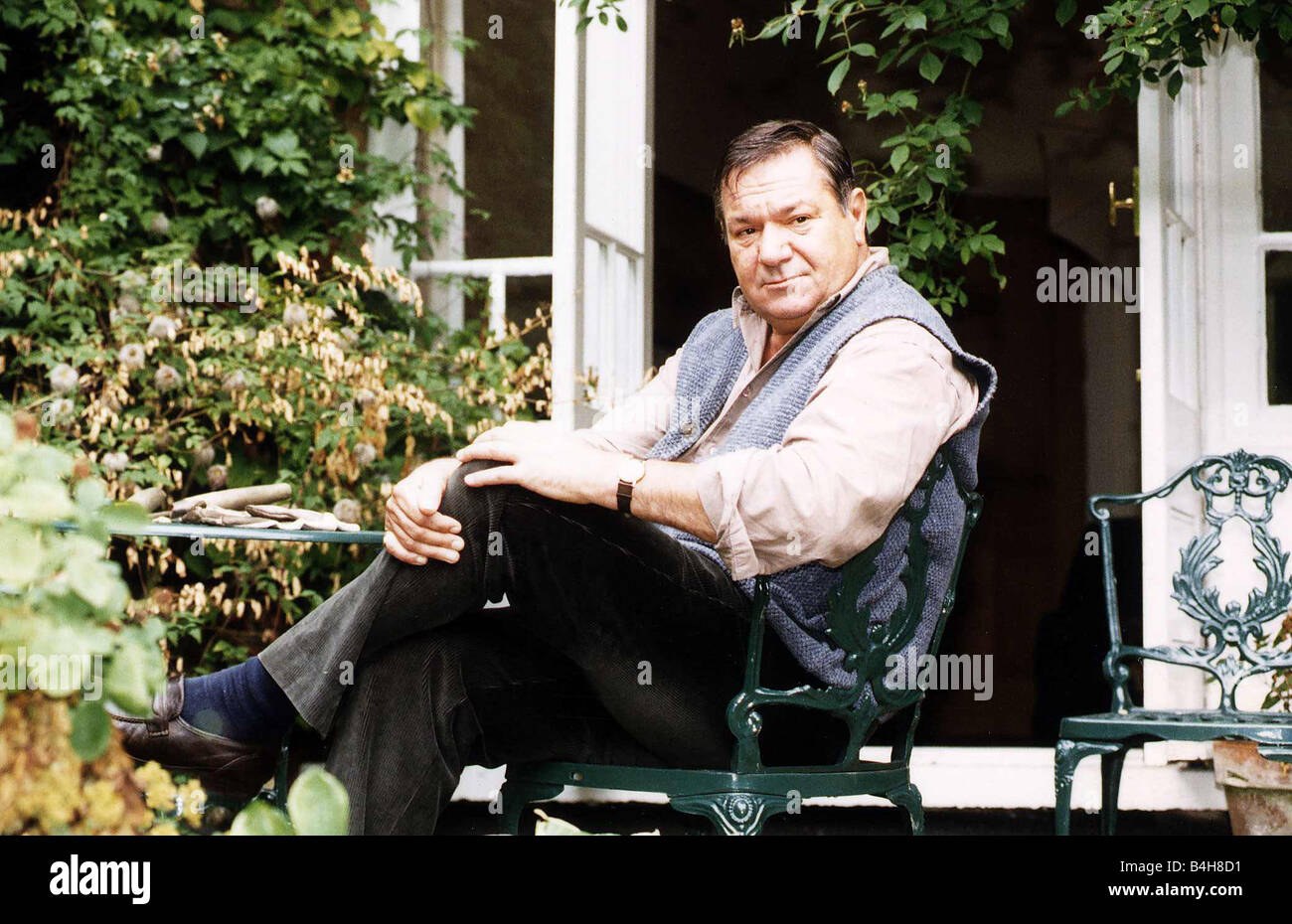 Michael Elphick Actor sitting in chair at home in garden Stock Photo