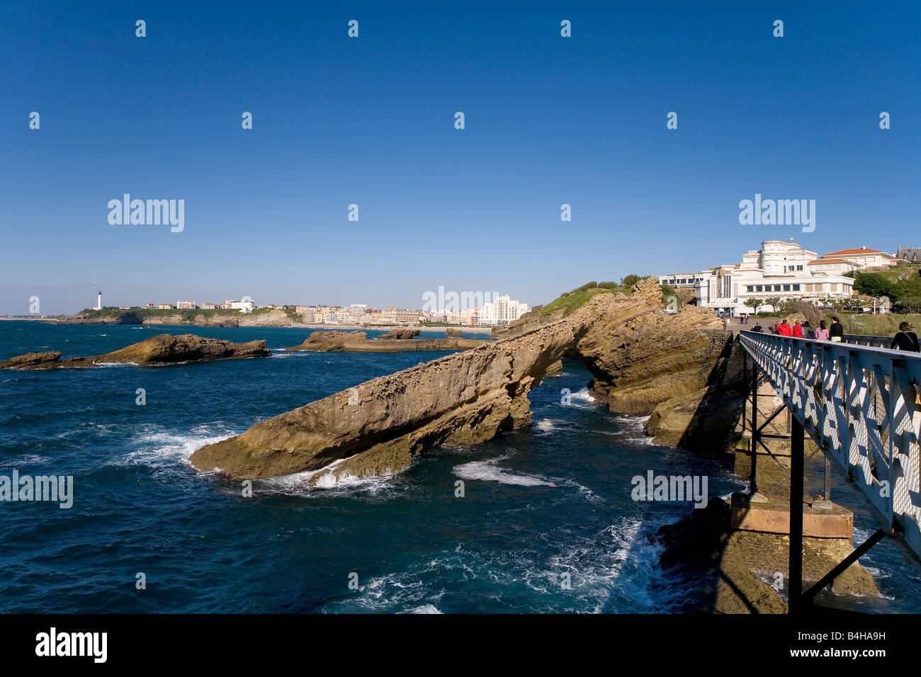 Tourists on bridge near natural arch lighthouse background Pointe Saint-Martin Biarritz Pyrenees-Atlantiques Aquitaine France Stock Photo