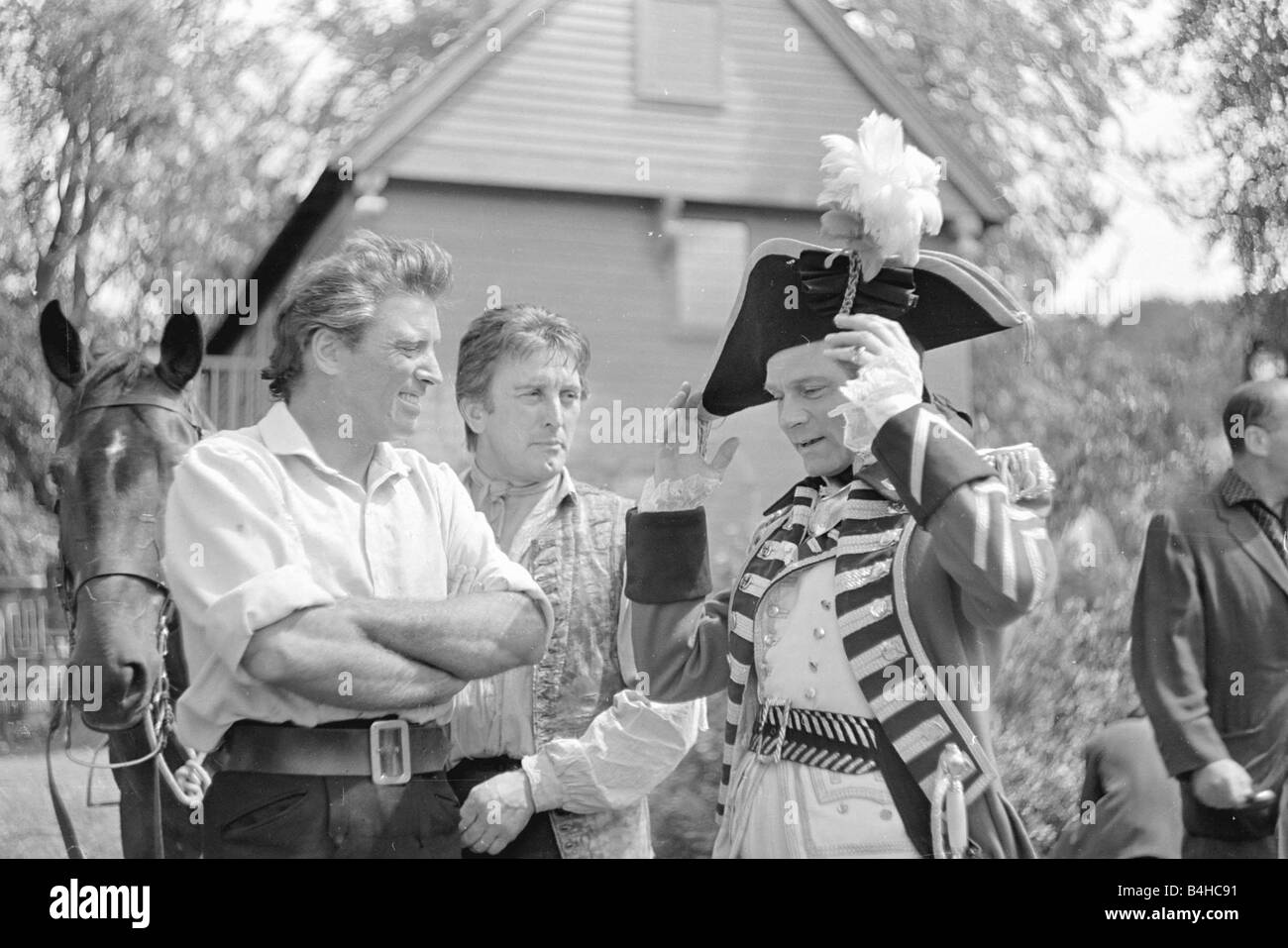 Burt Lancaster laughing with his actor colleagues during the filming of The Devils Disciple Film 18th century clothing hat wiuth fedder horse hats outdoors July 1958 1950s Mirrorpix Stock Photo