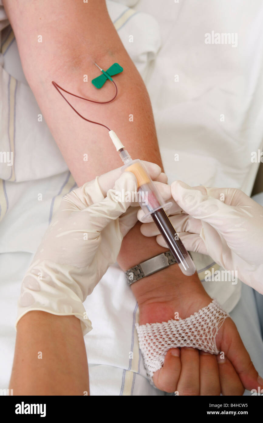 Close-up of person's hands taking blood sample from patient's arm Stock Photo