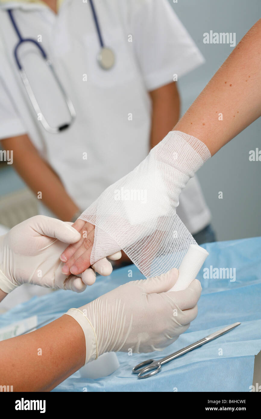 Close-up of nurse's hands wrapping patient's wrist Stock Photo