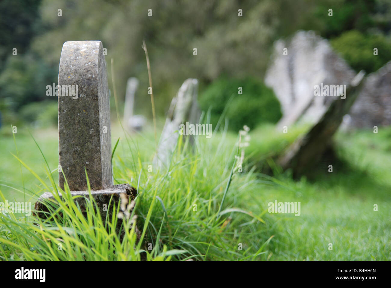 Basic Tobstone Simple tombstone in grass in grass with another tombstones blurred in ...