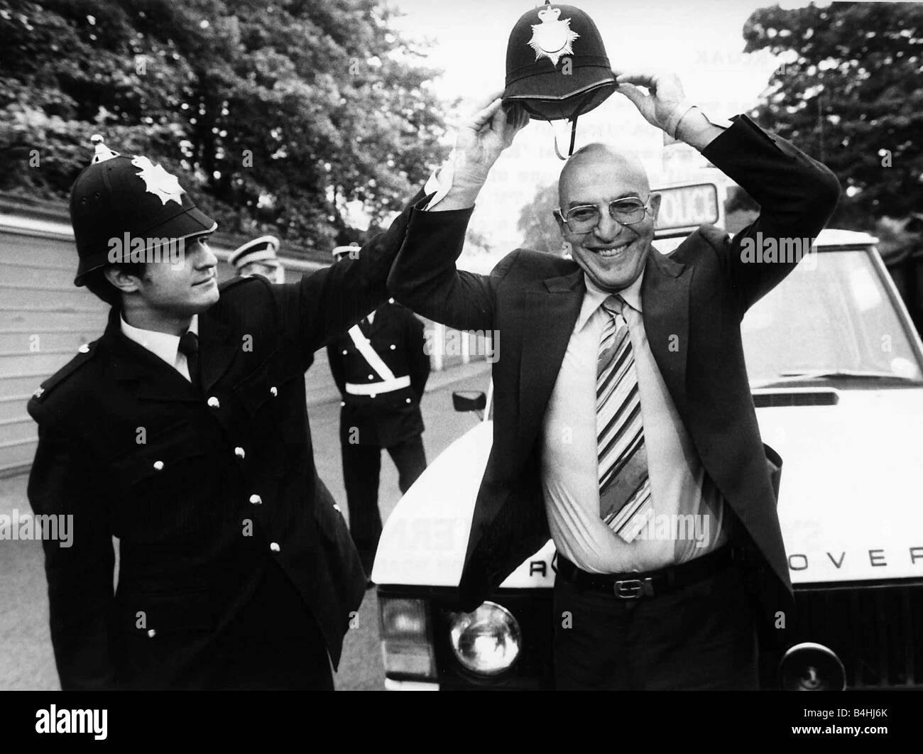 Telly Savalas Greek actor tries on police helmet June 1980 Stock Photo